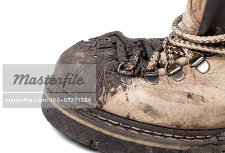Old dirty trekking boot isolated on white background. Close-up view.