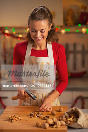 Happy young housewife chopping walnuts