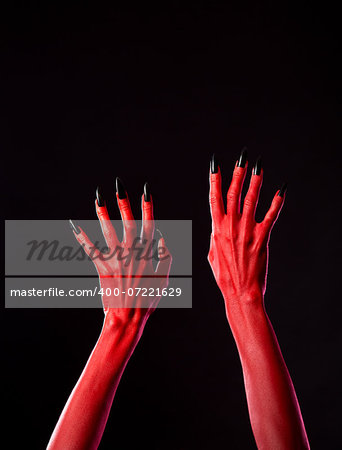 Red spooky devil hands with black nails, Halloween theme, studio shot on black background