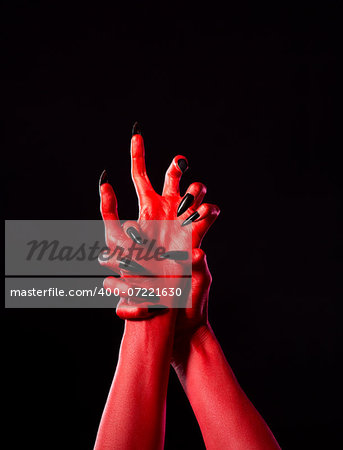 Red demonic hands with black nails, Halloween theme, isolated on black background