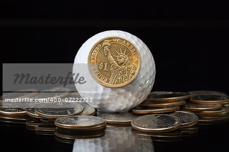 White golf ball and different U.S. dollar coins
