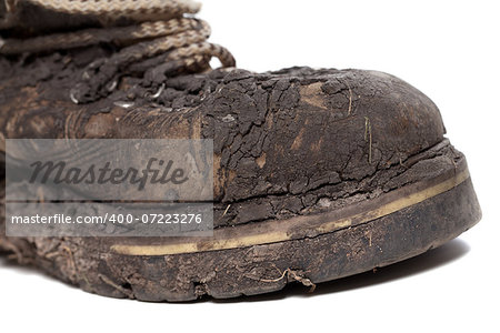 Old dirty hiking boot isolated on white background. Close-up view.