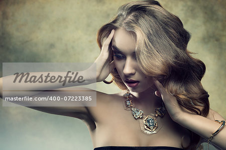 close-up portrait of splendid young girl with luxury style, cute long wavy hair and golden necklace