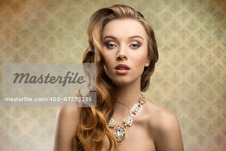 splendid girl with aristocratic style posing in fashion shoot with long wavy hair and luxury necklace