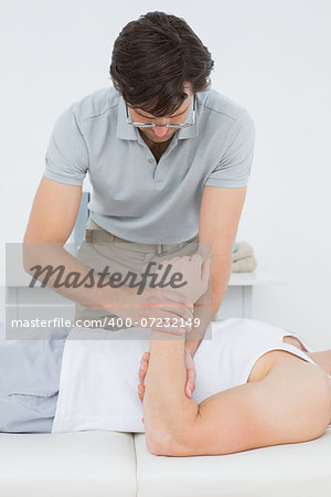 Male doctor examining a patients hand in the medical office