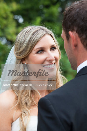 Close-up portrait of Bride with backview of Groom, looking at each other, Canada