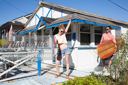 Couple on patio with surfboards, Breezy Point, Queens, New York, USA