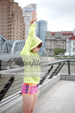 Young female jogger stretching