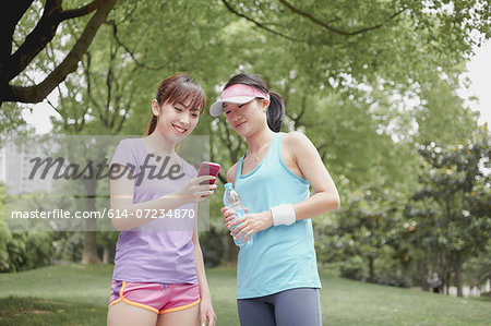 Female friends looking at cellphone in park
