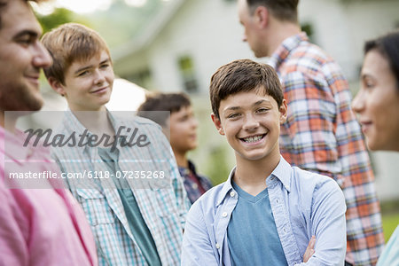 A group of people, adults and teenagers at a summer party.