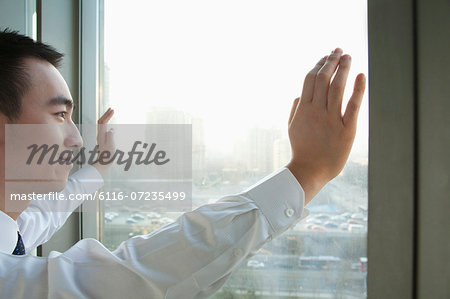 Young Businessman Looking out the window in Beijing