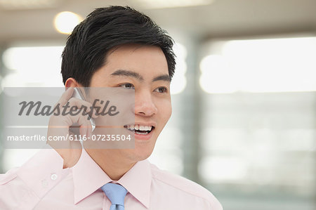 Young Businessman in pink button down shirt on the phone, Beijing, China