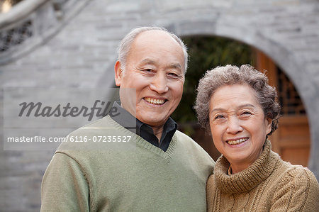 Portrait of senior couple in front of round arch, Beijing