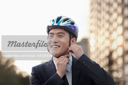 Businessman putting on cycling helmet