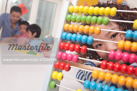Little Girl Looking Through Abacus at Camera