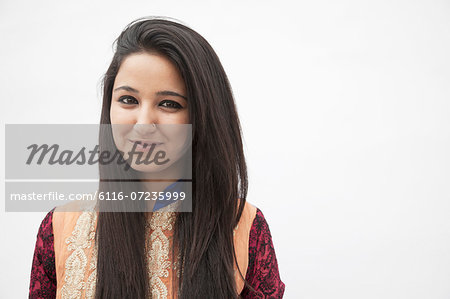 Portrait of smiling young woman wearing traditional clothing from Pakistan, studio shot