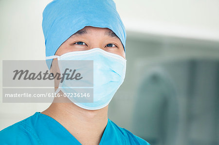Portrait of young surgeon wearing surgical mask in the operating room, close- up