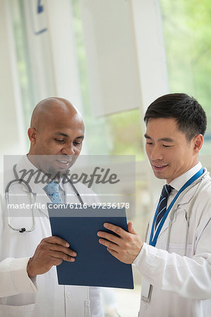 Two doctors looking down and consulting over medical record in the hospital