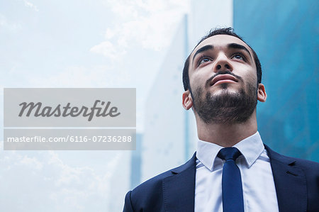 Portrait of serious young businessman, outdoors, business district