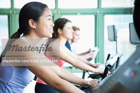 Young women exercising on fitness bikes in the gym