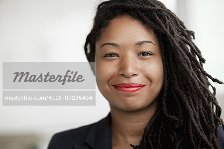 Portrait of smiling businesswoman with dreadlocks, head and shoulders