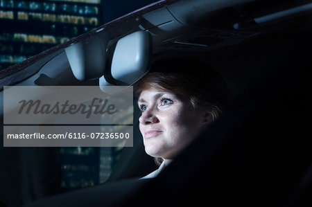 Businesswoman driving at night in the city