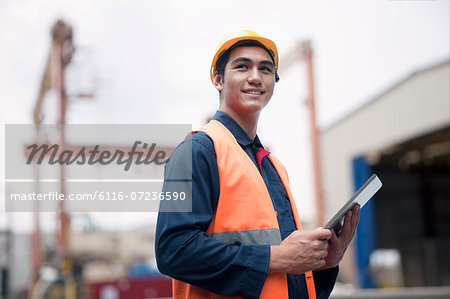 Proud young worker in protective work wear in a shipping yard