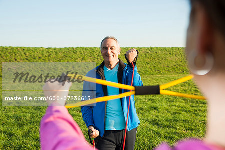 Man and Woman Exercising with Resistance Band Outdoors, Baden-Wurttemberg, Germany
