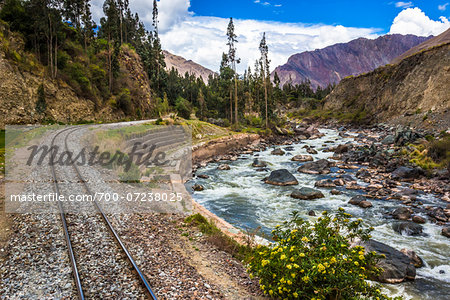 Train rails beside river on scenic journey through the Sacred Valley of the Incas in the Andes mountains, Peru