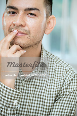 Mid adult man touching his lip