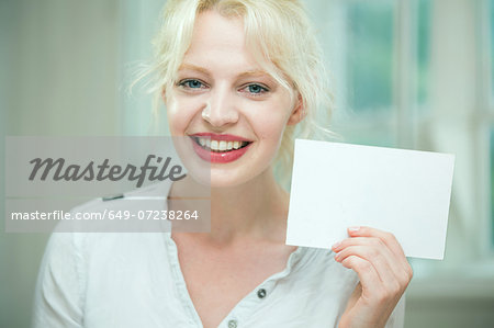 Young woman holding a blank card