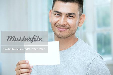 Mid adult man holding a blank card