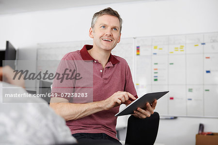 Man sitting in office using digital tablet