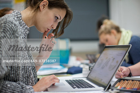 Woman using laptop in art class