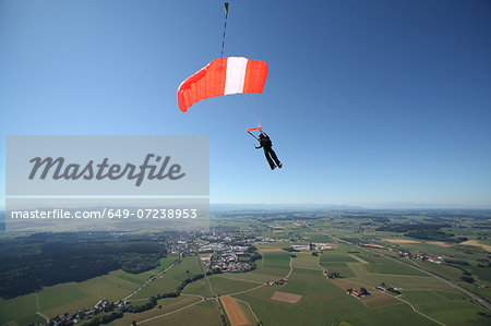 Skydiver parachuting down above Leutkirch, Bavaria, Germany