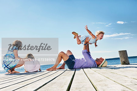 Family playing on jetty, Utvalnas, Gavle, Sweden Family playing on jetty, Utvalnas, Gavle, Sweden