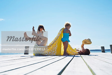 Young family fooling around on pier, Utvalnas, Gavle, Sweden