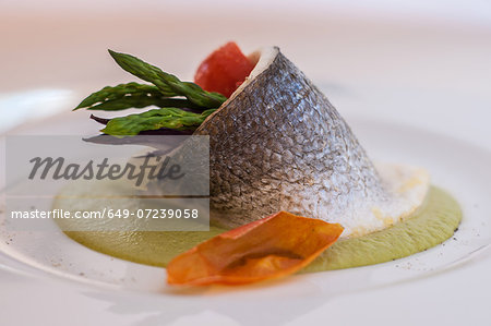 Still life with fish stuffed with asparagus and tomato