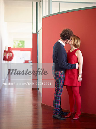Mid adult couple kissing in corridor
