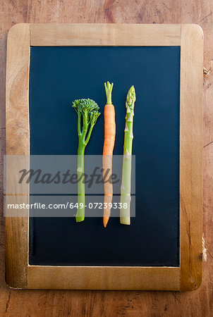 Carrot, brocolli and apsaragus on blackboard, still life