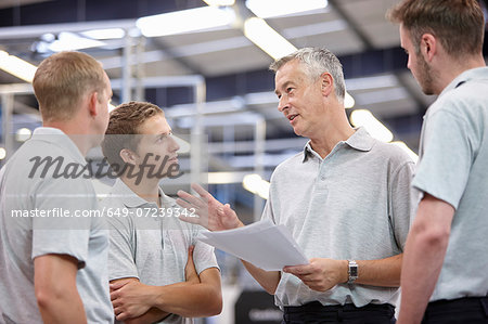 Manager and workers meeting in engineering factory