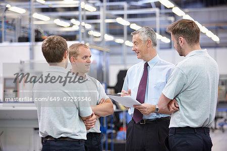 Workers and manager meeting in engineering warehouse