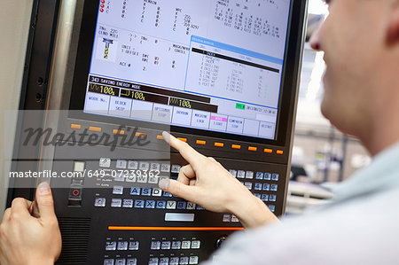 Worker checking computer monitor in engineering factory