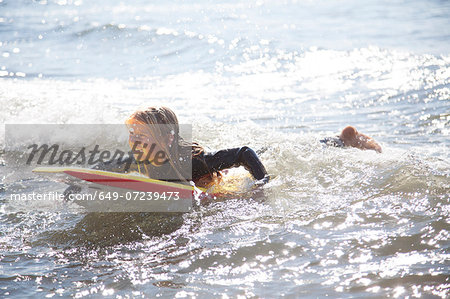 Portrait of girl on surfboard, Wales, UK