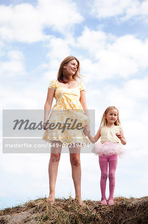 Mother and daughter holding hands on dunes, Wales, UK