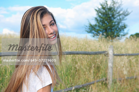 Teenage girl by wooden fence, Tuscany, Italy