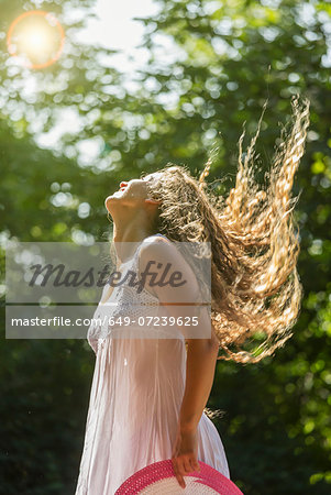 Teenage girl wearing white sundress tossing long hair, Prague, Czech Republic