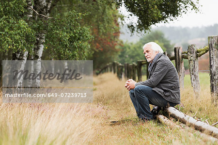 Senior man sitting on log