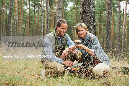 Mid adult couple foraging for mushrooms in forest