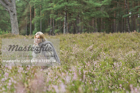 Mid adult woman in meadow with hand on chin